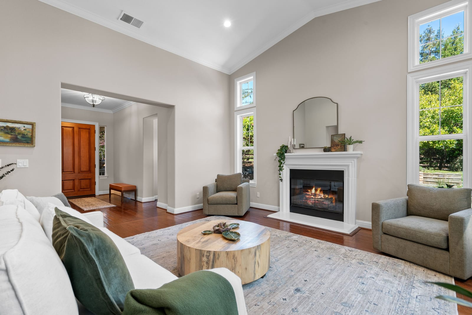 Living room with vaulted ceiling and white-mantel fireplace