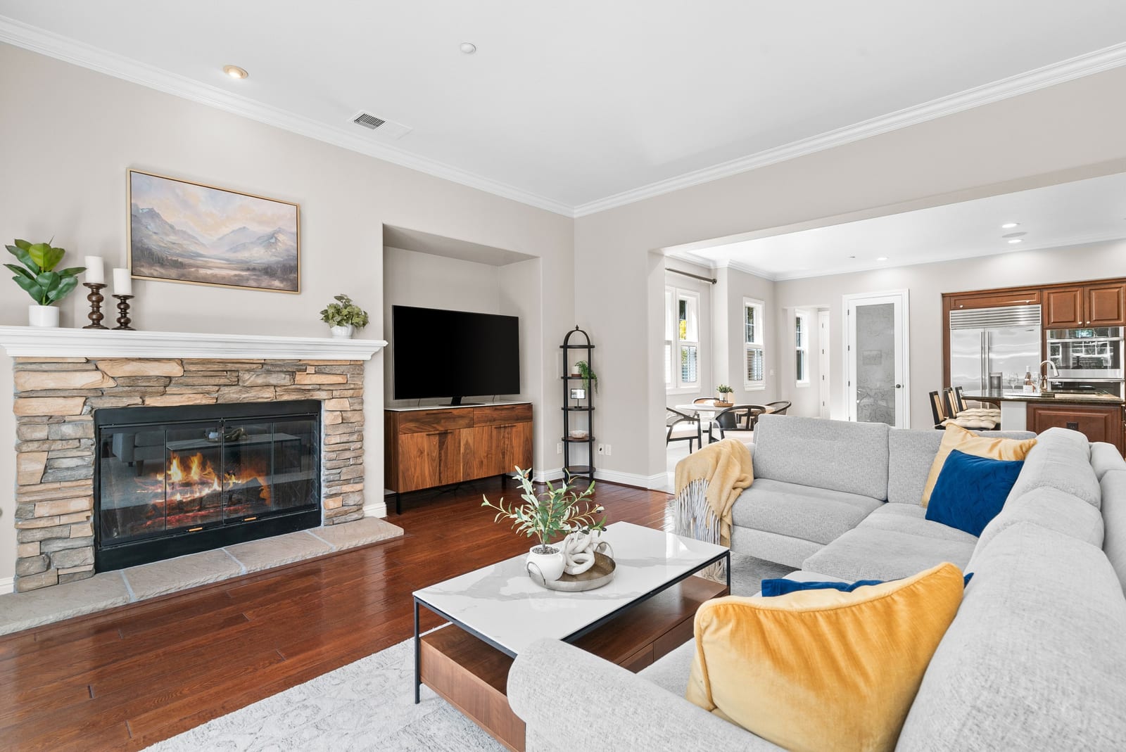 Family room with stone fireplace and open kitchen beyond